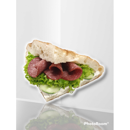 Fladenbrot belegt mit Rindersalami, Sauce, Salat und Gurken